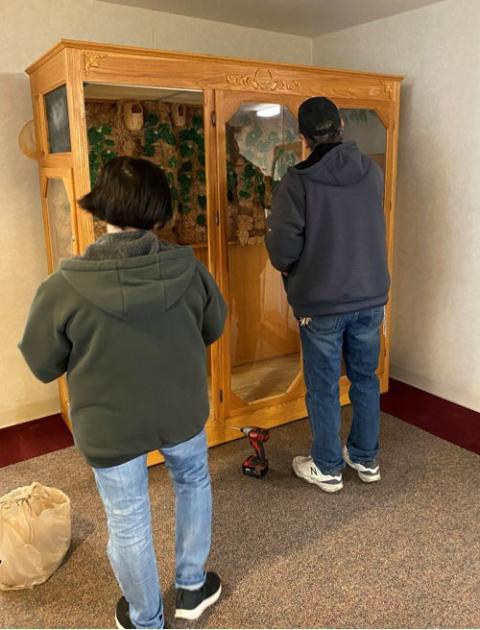 The buyers of an aviary dismantle it to bring home for their 15-year-old iguana. (Courtesy of the Sisters of Mercy)