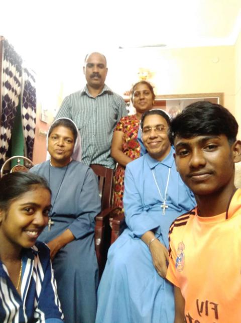 Sr. Felcy Mangalath, seated left in second row, a member of the Missionary Sisters of the Queen of Apostles, and her companion, Sister Tessy, with the family that hosted them during Home Mission (Courtesy of Felcy Mangalath)