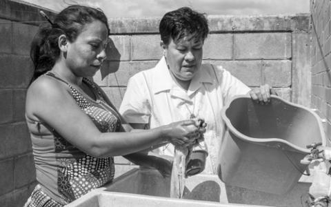 Migrants at the Albergue Hermanos en el Camino in Ixtepec, Mexico, receive new clothes and have access to laundry. Here, Guardian Angel Sr. Lorena Hernández Jiménez helps one wash her clothes.