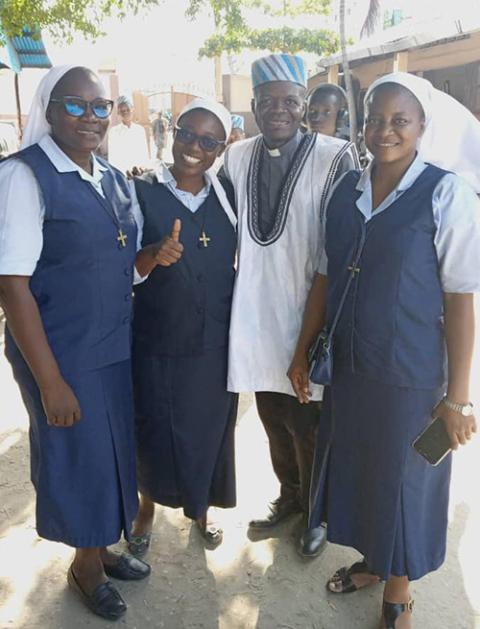Sr. Elise Solange Maga (second from left) with two of her fellow Sisters of the Divine Will and a newly ordained Jesuit priest, at the celebration after his Thanksgiving Mass (Courtesy of Elise Solange Maga)