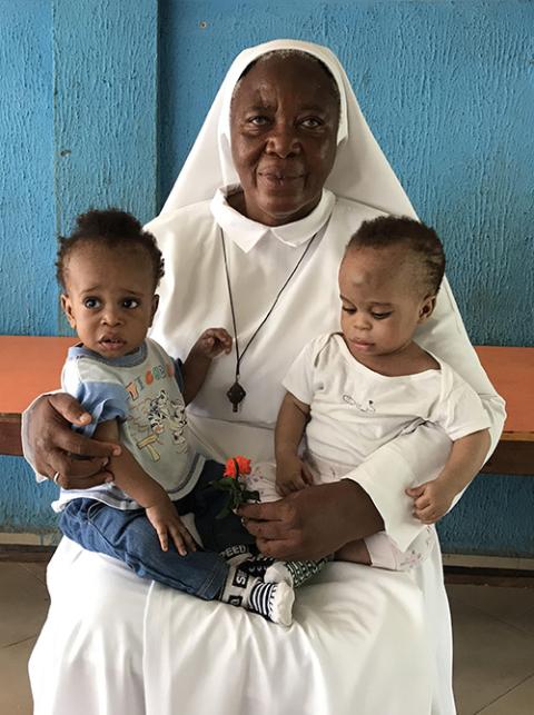 Matilda Inyang Sr. Matilda Inyang with two children at the Mother Charles Walker Children Home on May 7 at the Handmaids of the Holy Child Jesus convent in Uyo, Nigeria. Many of the children at the home had family who believed they were witches. (Valentine Iwenwanne)