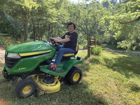 Benedictine Sr. Sue Fazzini cuts the grass at home in rural Greene County, Pennsylvania. (Provided photo)