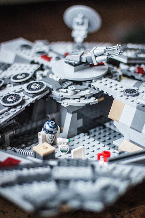 Lego "Star Wars" minifigures of droids R2-D2 and D-0 inside a Lego model of the Millennium Falcon ship. (Unsplash/Kristine Tumanyan)