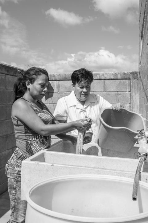 Los migrantes del Albergue Hermanos en el Camino en Ixtepec, México, reciben ropa nueva y pueden utilizar la lavandería. Aquí, la hermana del Ángel de la Guarda Lorena Hernández Jiménez ayuda a una persona a lavar su ropa