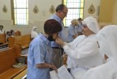 Mother Lourdes García Muñoz presents a crucifix to Elsa Villa, a former Mexican diplomat, to kiss Aug. 7 as Villa and four other laypeople pledged to assist the nuns in caring for those who are terminally ill in their homes.