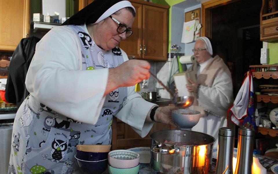 Sr. Mateusza Trynda, the local superior of the Dominican convent and a resident of Zhovkva, Ukraine, for 28 years, serves soup for guests during a midday candlelit meal Nov. 24. (GSR photo/Chris Herlinger)