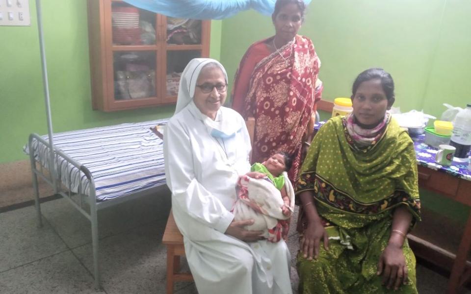 Sr. Sandra Joseph, a member of Sisters of Charity of Sts. Bartolomea Capitanio and Vincenza Gerosa, visits a newborn baby and their relatives at St. Vincent Hospital in Dinajpur, Bangladesh, where she has ministered for 42 years. (Sumon Corraya)