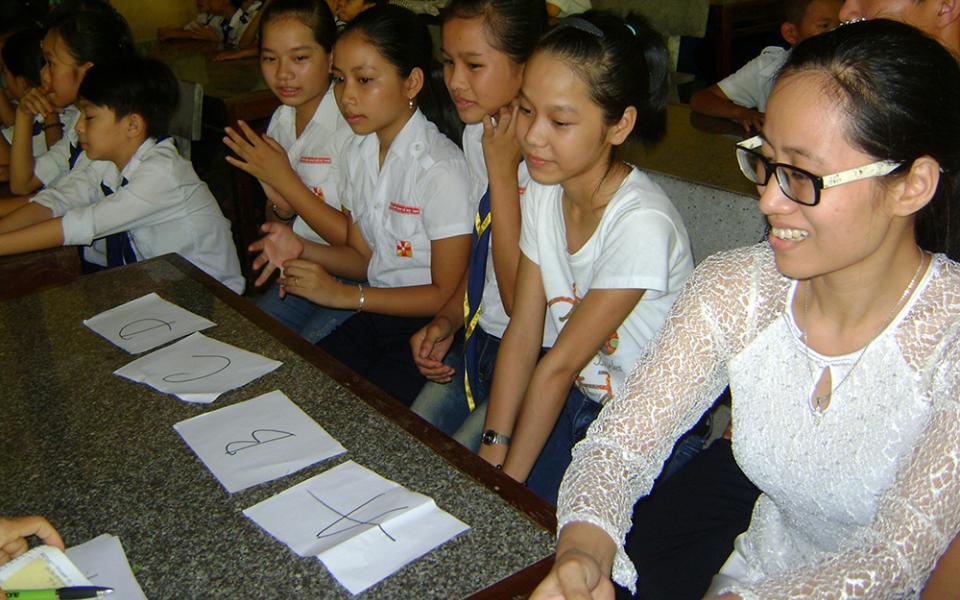 Apostolate Auxiliaries Sr. Mary Ton Nu Thu Tra (right) teaches catechism to children at Quang Ngan Parish, July 2 in Vietnam's Thua Thien Hue province. (GSR photo/Joachim Pham)