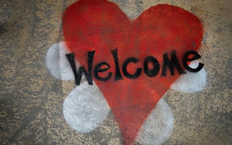 A red heart is displayed spray painted on a tan wall in this photo illustration. (Unsplash/Nick Fewings)