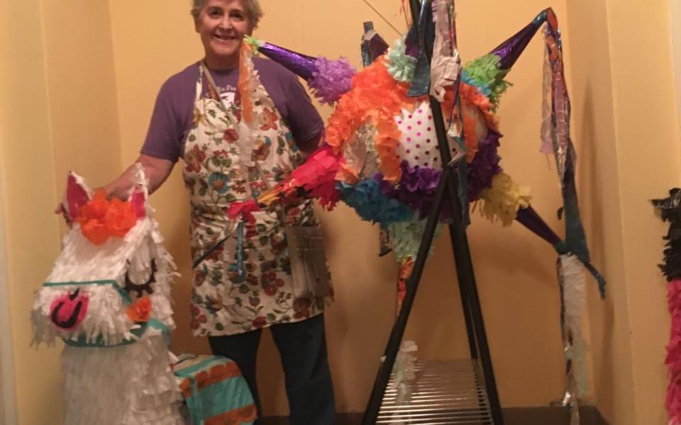 Woman stands with pinatas.