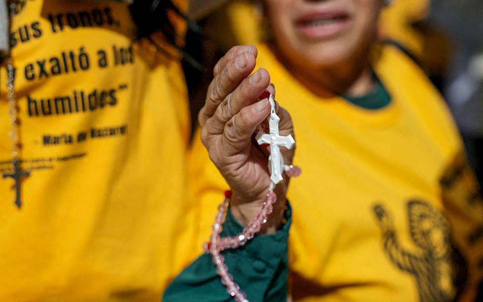 A woman holds a rosary as members of a Catholic group take part in a eucharistic procession near the U.S. Immigration and Customs Enforcement (ICE) Broadview facility in Chicago Oct. 11, 2025. (OSV News/Reuters/Jeenah Moon)