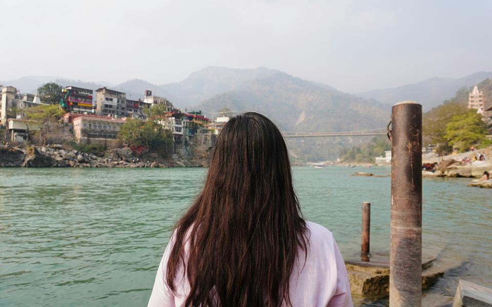 A woman looks out over a body of water. (Unsplash/Prashant)