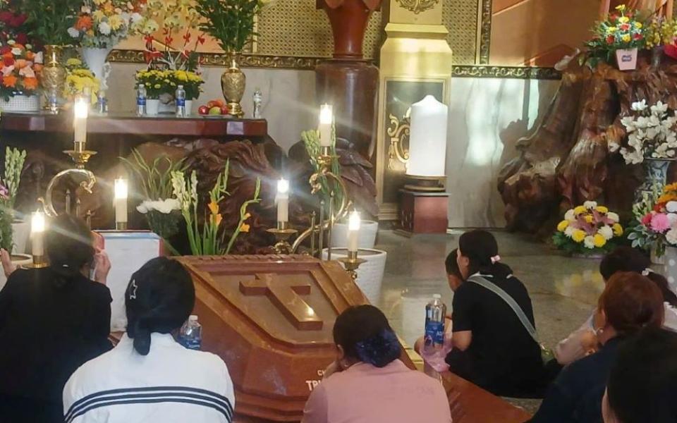Vietnamese faithful pray beside the grave of Fr. Francis Xavier Truong Buu Diep at Tac Say Pilgrimage Center in southern Vietnam. Father Francis, a martyr, is to be canonized as a Catholic saint on July 2 at the center. (Courtesy of Mary Nguyen)