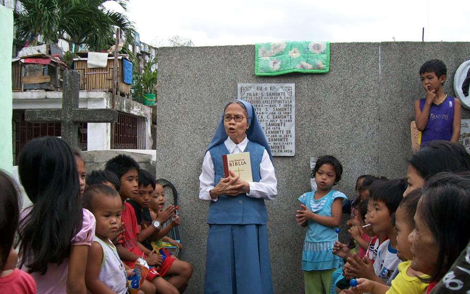 Sr. Evangelina Canag teaches Bible lessons to children living inside a public cemetery in Manila in 2008. (Courtesy of Daughters of St. Paul)