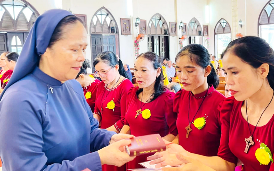 Sr. Maria Madelene Le Thi Bich offers Bibles to newcomers to the group of former sisters in Hue, Vietnam, on Sept. 14, 2025. (Joachim Pham)