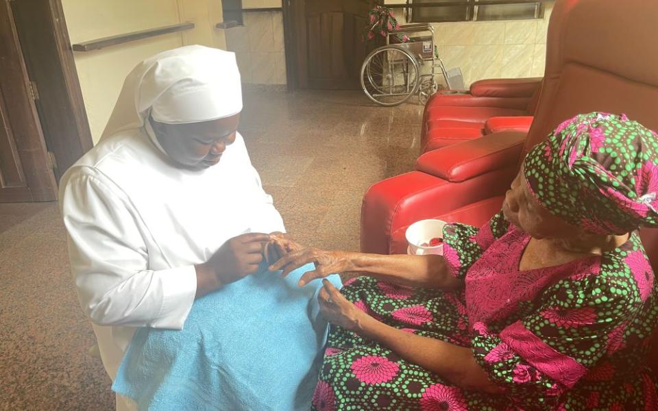 Sr. Gertrude Anozie trims a female resident's nails at the Our Lady of Perpetual Help Home for the Elderly in the Awkunanaw area of Enugu, southeastern Nigeria. (John Chukwu)