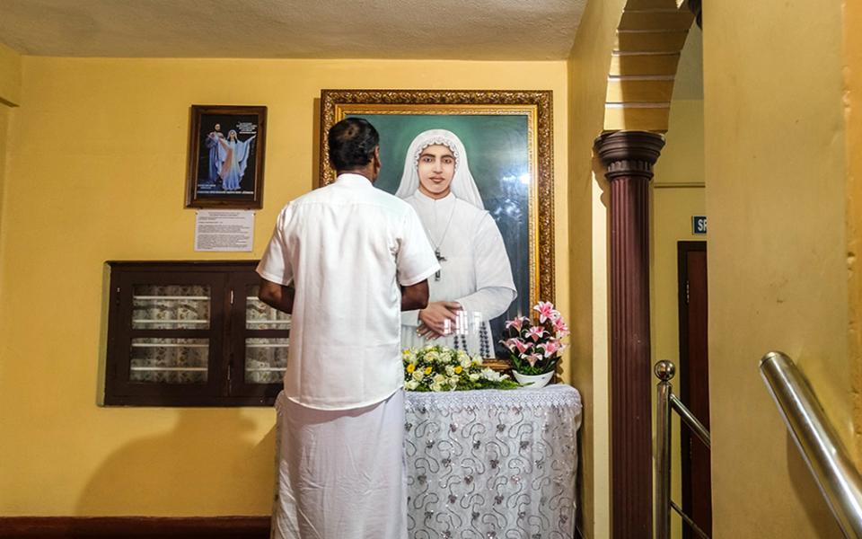 A man prays before a portrait of Venerable Sr. Maria Celine Kannanaikal at the  provincial house of the Ursulines of Mary Immaculate in Payyambalam, a suburb of Kannur town in the southwestern Indian state of Kerala. (George Kommattam)