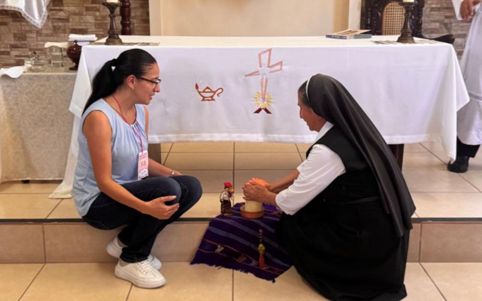Sr. Indra Monterroso Padilla, of the Bethlemite Sisters, Daughters of the Sacred Heart of Jesus, lights a candle with laywoman Martha Calderon at a chapel in El Paraíso, El Salvador, where women religious and laywomen gathered Sept. 12, 2026, to keep the work of the synod alive. (GSR photo/Rhina Guidos)