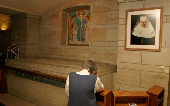 A Sister of the Blessed Sacrament prays before the tomb of the congregation's foundress, St. Katharine Drexel, in May 2016 at the former motherhouse in Bensalem, Pennsylvania. (CNS/CatholicPhilly.com/Sarah Webb)