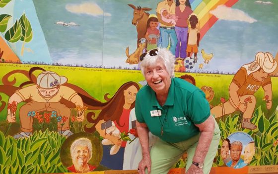 Sr. Ann Kendrick poses with a mural inside Hope CommUnity Center in Apopka, Florida. (GSR photo/Gail DeGeorge)