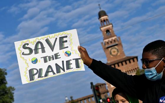 A demonstrator holds up a sign at an Oct. 1 Fridays for Future climate strike in Milan, Italy, ahead of the Oct. 31-Nov. 12 U.N. Climate Change Conference in Glasgow, Scotland. (CNS/Reuters/Flavio Lo Scalzo)