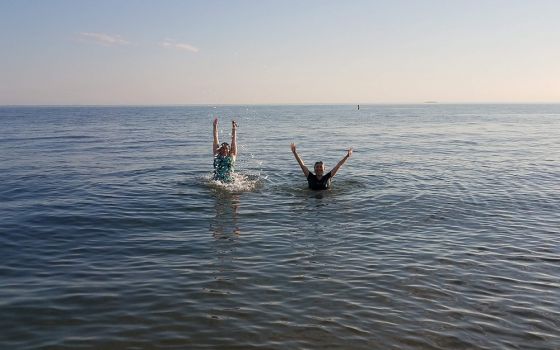 Dominican of Peace Sr. Ana Gonzalez, left, and Lovers of the Holy Cross Sr. AnHoa Nguyen enjoy the water of the Long Island Sound at Hammonasset Beach State Park in Madison, Connecticut, in summer 2020. (Provided photo)