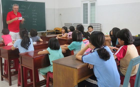 Philip MacLaurin teaches English for children at the Binh Trieu warm shelter run by the Friends for Street Children association, which serves children in poverty or in need. (Mary Nguyen Thi Phuong Lan)