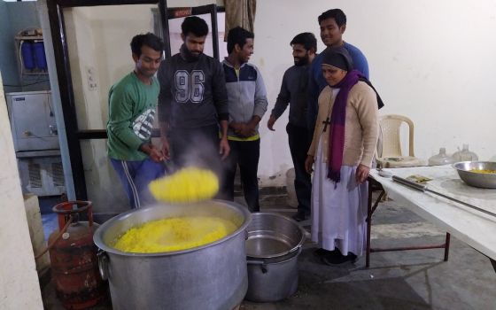 Seminarians and Sr. Preetha Varghese, a member of the Sisters of Imitation of Christ who is in charge of the Food for Hungry program, cook food at the cathedral hall to distribute to those who are in need. (Jessy Joseph)