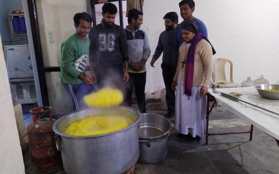 Seminarians and Sr. Preetha Varghese, a member of the Sisters of Imitation of Christ who is in charge of the Food for Hungry program, cook food at the cathedral hall to distribute to those who are in need. (Jessy Joseph)