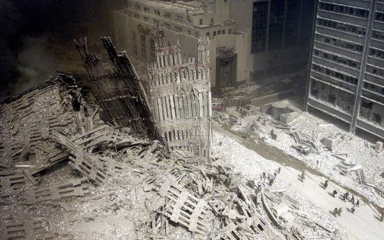 Firefighters walk amid rubble near the base of the destroyed south tower of the World Trade Center on Sept. 11, 2001. (CNS/Reuters)