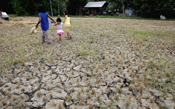 A woman and children walk through a drought-stricken rice field in Cebu, Philippines, in April 2016. (CNS/Reuters/Jay Rommel Labra)