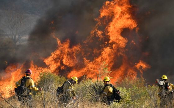 Firefighters battle a wind-driven wildfire Oct. 25 in Canyon Country near Los Angeles. (CNS/Reuters/Gene Blevins)