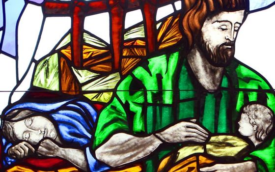 A depiction of St. Joseph cradling the infant Jesus while Mary sleeps is seen in a stained-glass window at St. Patrick Church in Smithtown, New York. (CNS/Gregory A. Shemitz)