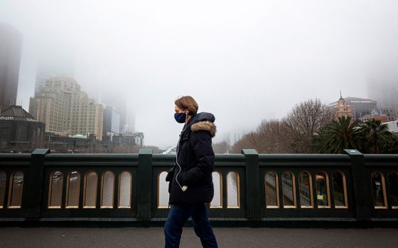 A person in a protective face mask walks along the Princes Bridge in Melbourne, Australia, July 17, 2020, during a lockdown in response to the coronavirus pandemic. (CNS/Reuters/Daniel Pockett)
