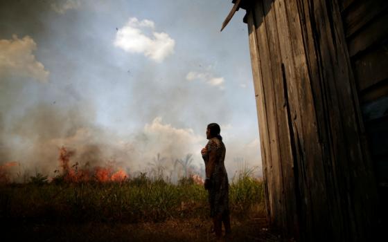 Miraceli de Oliveira reacts as fire approaches her house in an area of the Amazon rainforest near Porto Velho, Brazil, Aug. 16. (CNS/Reuters/Ueslei Marcelino)