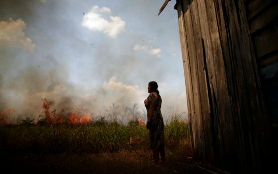 Miraceli de Oliveira reacts as fire approaches her house in an area of the Amazon rainforest near Porto Velho, Brazil, Aug. 16. (CNS/Reuters/Ueslei Marcelino)