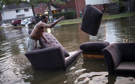 A man moves his flood-damaged sofas in Houston in the wake of Hurricane Harvey in 2017. Scientists say restoring and preserving wetlands could prevent millions of dollars' worth of damage from severe storms. (CNS photo/Adrees Latif, Reuters)