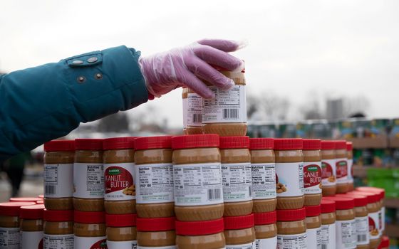 A volunteer from Forgotten Harvest food bank in Warren, Michigan, sorts jars of peanut butter during a mobile food pantry distribution Dec. 21, 2020. (CNS/Reuters/Emily Elconin)