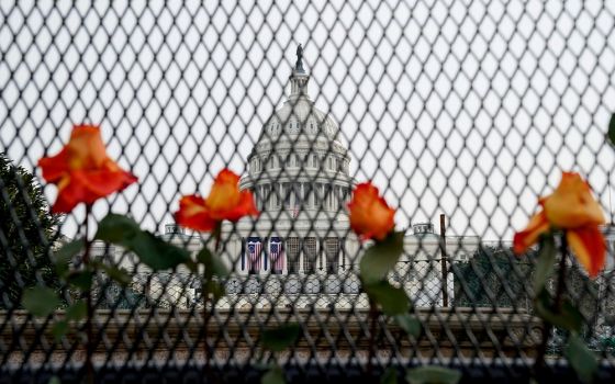 Flowers are placed in security fencing around the U.S. Capitol in Washington Jan. 11, days after supporters of President Donald Trump stormed the building. (CNS/Reuters/Erin Scott)