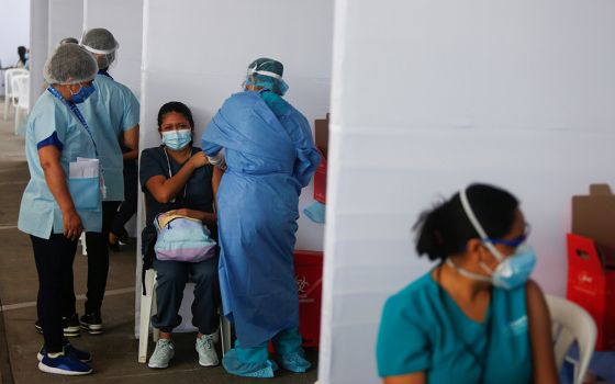 A health care worker receives a dose of Sinopharm's COVID-19 vaccine Feb. 9 in Lima, Peru. Peru's bishops denounced the giving of vaccines to VIPs instead of essential workers after the vaccine became available. (CNS/Reuters/Sebastian Castaneda)