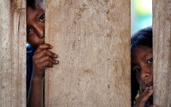 Children look on as relatives receive the Sinovac COVID-19 vaccine March 3 in São Gabriel da Cachoeira, Brazil. (CNS/Reuters/Ueslei Marcelino)