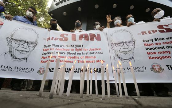 People hold a banner during a July 6 prayer service for Jesuit Fr. Stan Swamy in Mumbai, India, the day after he died at a hospital.  (CNS/Reuters/Francis Mascarenhas)