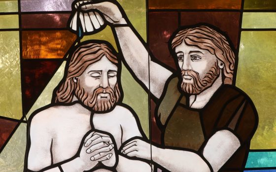 The baptism of Christ by John the Baptist is depicted in a stained-glass window at St. Anthony's Church in North Beach, Md.. July 15, 2021. (CNS photo/Bob Roller)