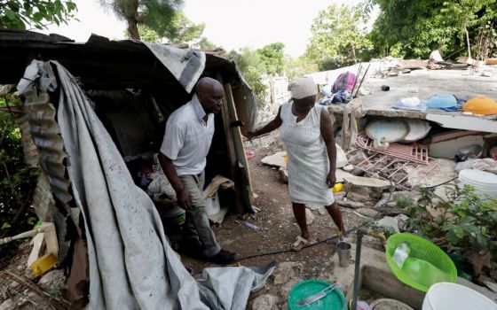 Sisters in Haiti are doing their best to continue their ministry and respond to emergency needs after the Aug. 14 earthquake. Here, Manithe Simon and his wife, Wisner Desrosier, walk through their collapsed home on Aug. 22. (CNS/Reuters/Henry Romero)