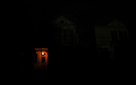 A front porch in New Orleans is lit by a flame on a dark street Aug. 31 in the midst of a power outage caused by Hurricane Ida. (CNS/Reuters/Leah Millis)