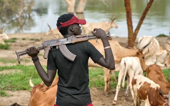 A cattle keeper holds an assault rifle Sept. 1 in Mogok, South Sudan.