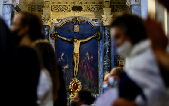 A crucifix is seen as people pray during a Mass at the cathedral Oct. 10 in Nice, France. (CNS/Reuters/Eric Gaillard)