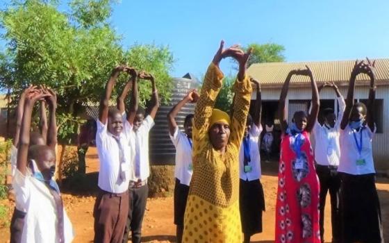 people standing in a line stretching their arms to the sky