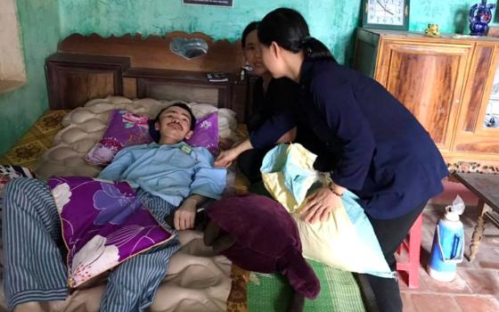 Daughters of Our Lady of the Visitation Sr. Mary Bonaventure Nguyen Thi Thien (second from right) and another sister visit Bartholomew Tran Dao The at his home Aug. 6. (GSR photo/Joachim Pham)