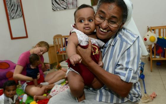 Nun holds child.